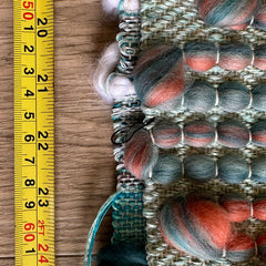 Handwoven fabric with a measuring tape besided it marking the length