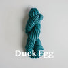 Skein of super chunky yarn in duck egg colour with title written across the wool
