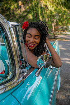 woman with locs leaning on door of the car