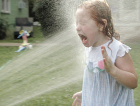 Girl being sprayed by a hose
