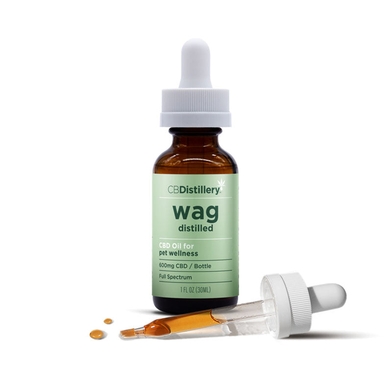 Dropper of CBD oil in front of CBDistillery Wag Distilled Pet Tincture bottle with green label