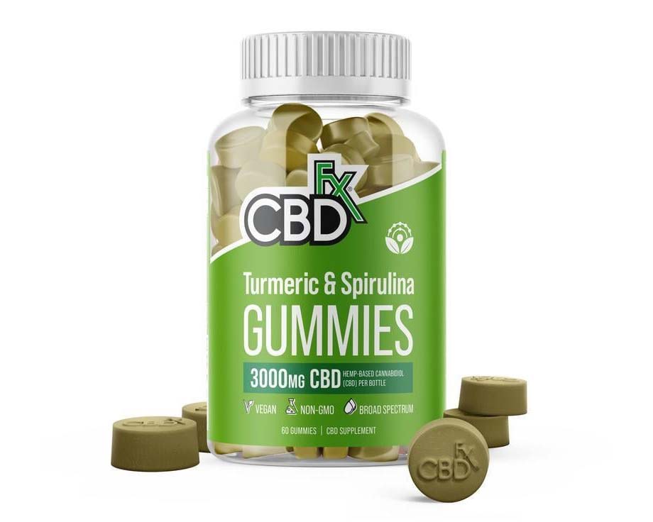 a jar of CBDfx Turmeric and Spirulina CBD Gummies surrounded with several green gummies