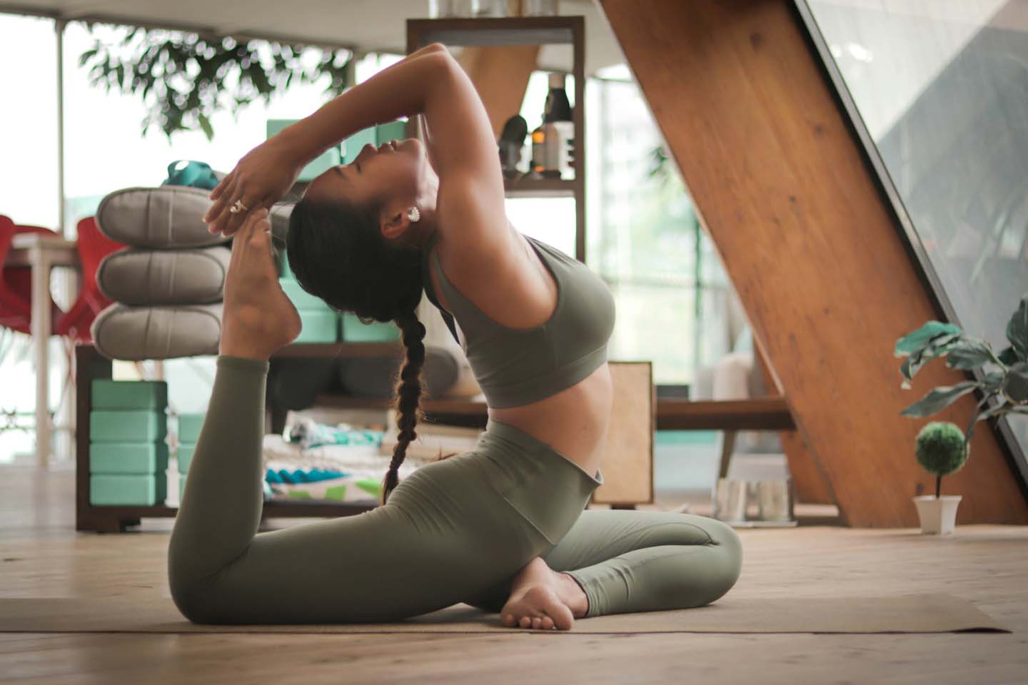 A woman in doing a yoga pose indoors