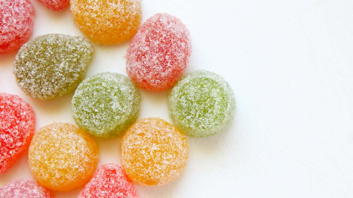 Multicolored gummies on a white surface