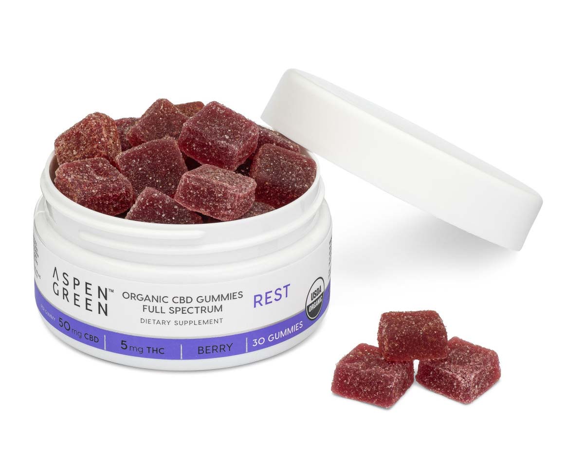 Dark red gummies in opened white plastic jar of Aspen Green Rest Organic Full Spectrum CBD Gummies
