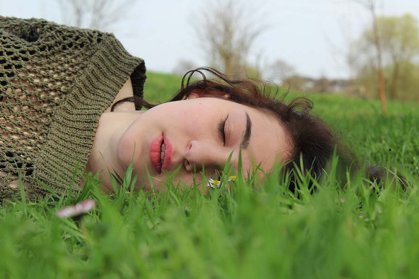 A woman sleeping on a grass field