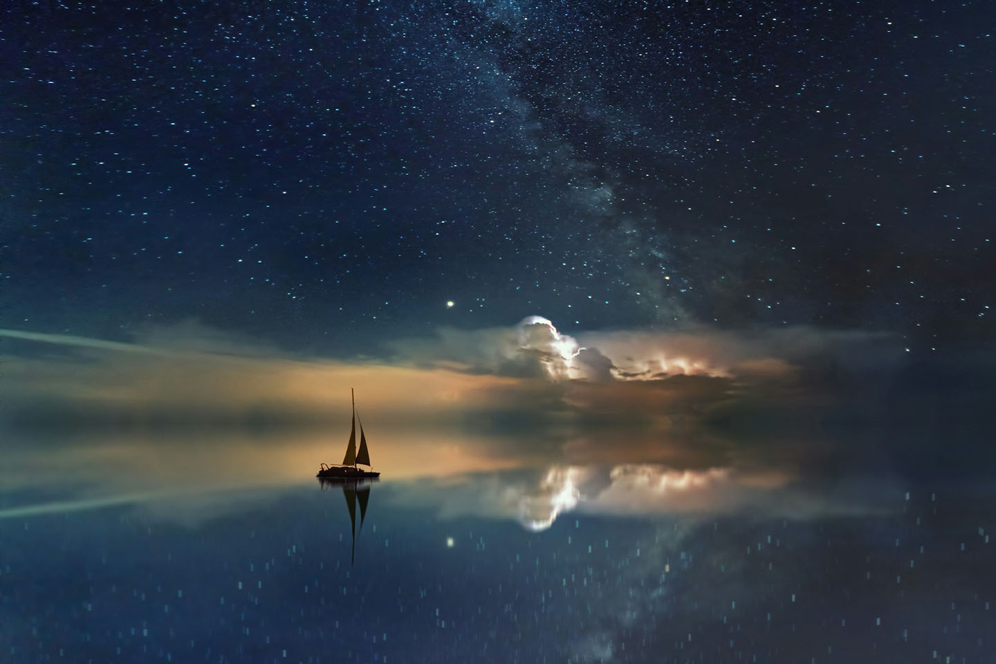 small sail boat under starry night sky, reflecting in the still water