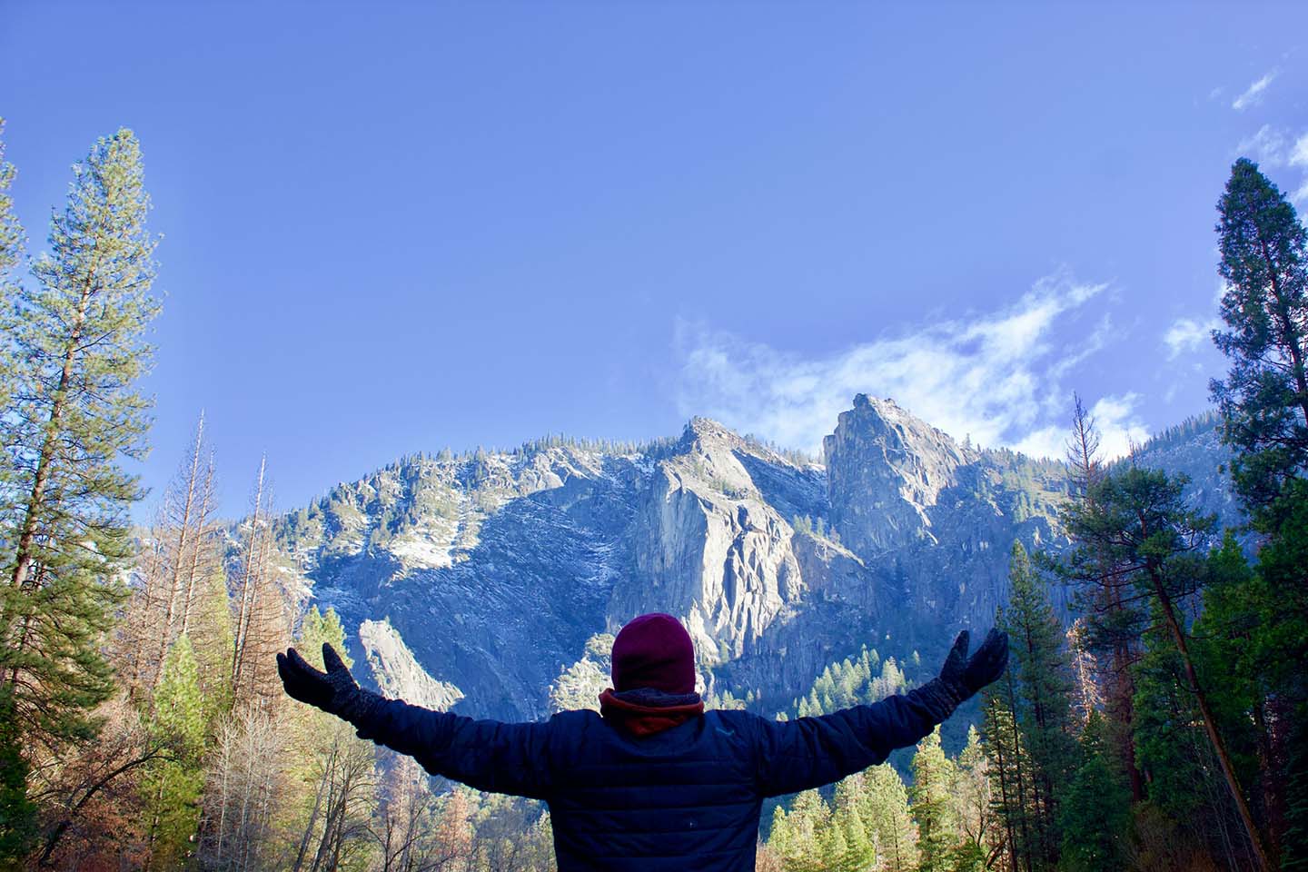 a person in nature looking at mountains while stretching arms and feeling good
