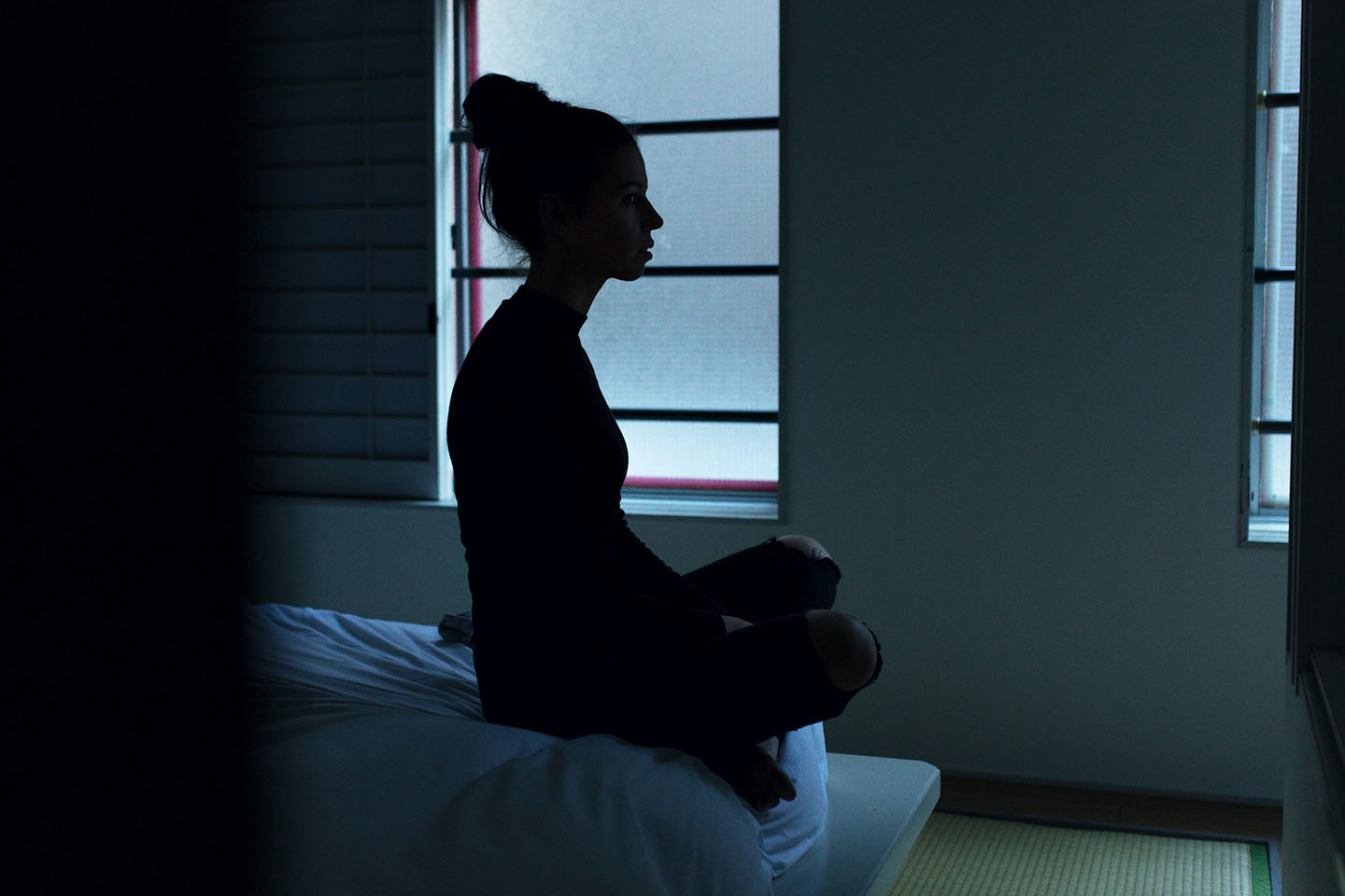 silhouette of a woman sitting on bed