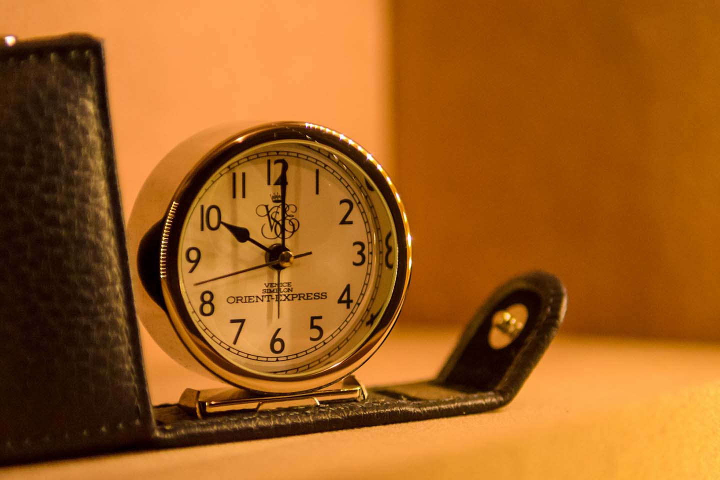 a white and black table clock in a warm lighted room