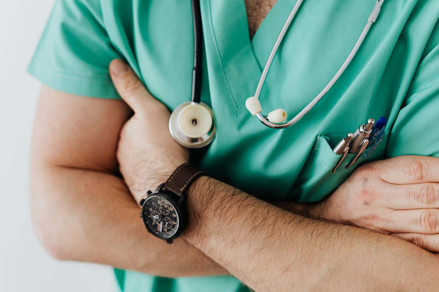 Closeup of a medical professional in green scrubs with a stethoscope