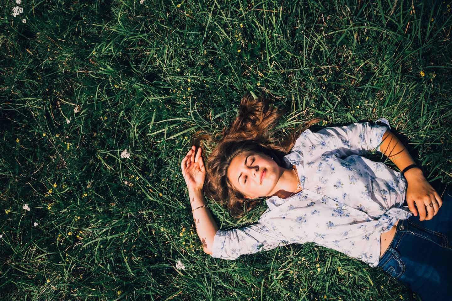 a woman sleeping peacefully on the grass