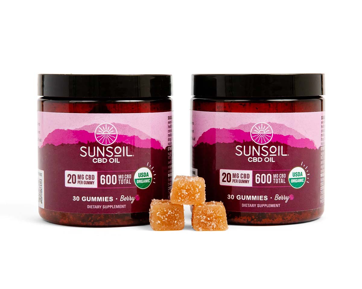 two jars of Sunsoil gummies behind three stacked gummies