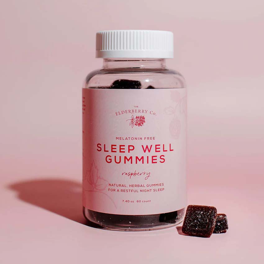 Dark red gummies next to jar with pink label