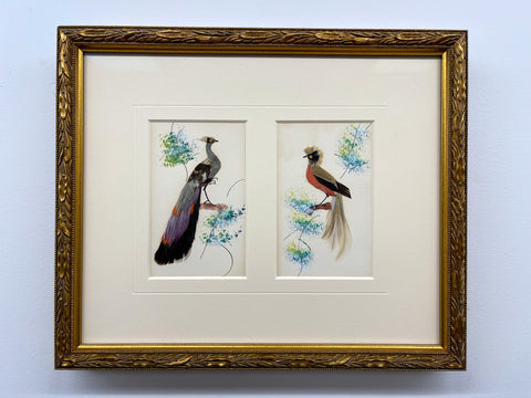 Two birds made of actual feathers framed in a gold feather detailed frame