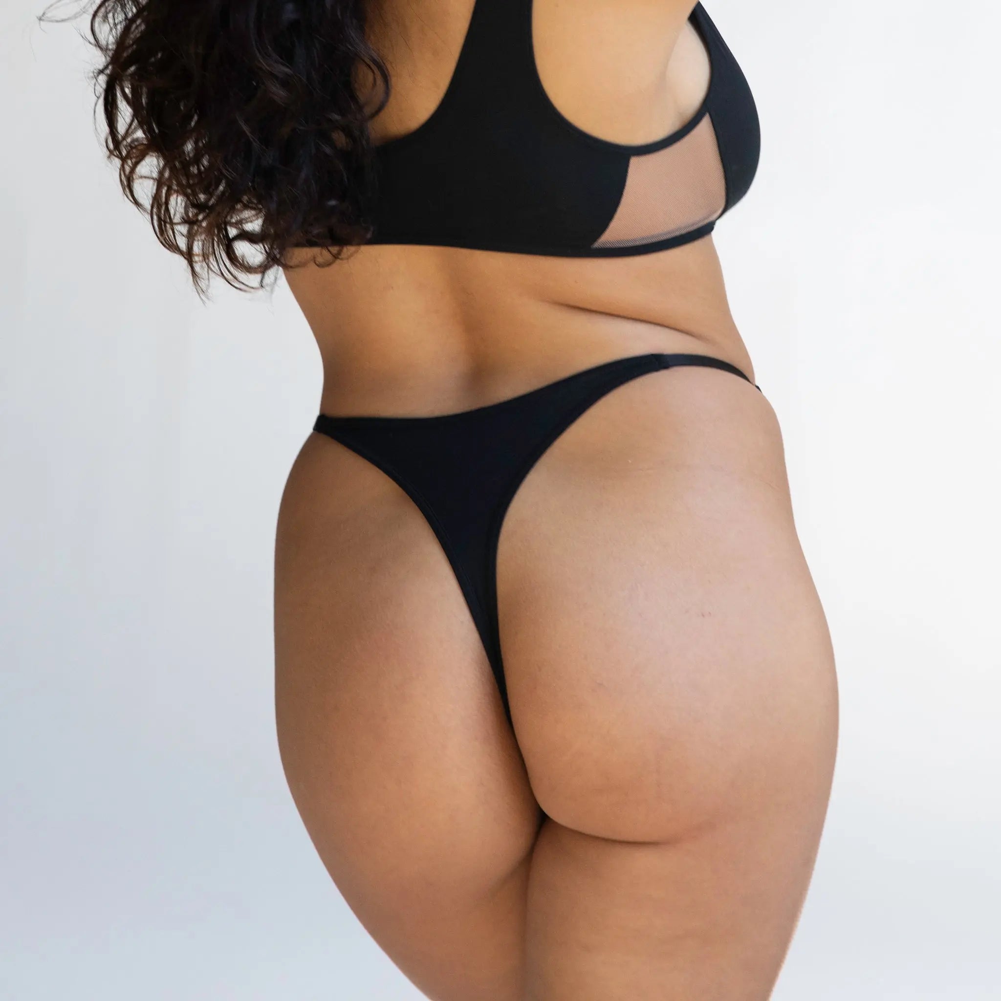 https://cdn.shopify.com/s/files/1/0044/1840/4438/products/Monique_Morin_Core_black_thong_Back_Isabella_squared.jpg?v=1700202094