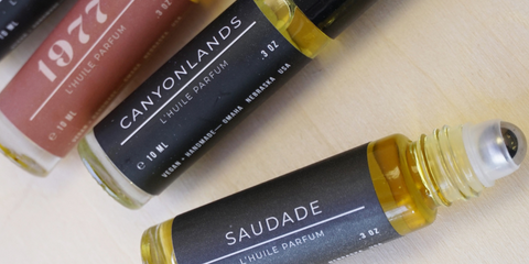 Nomad Wax Co perfume oil rollers with neutral labels on light background