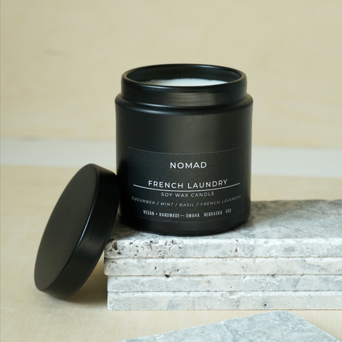 matte black Nomad French Laundry Noir candle on stone tiles