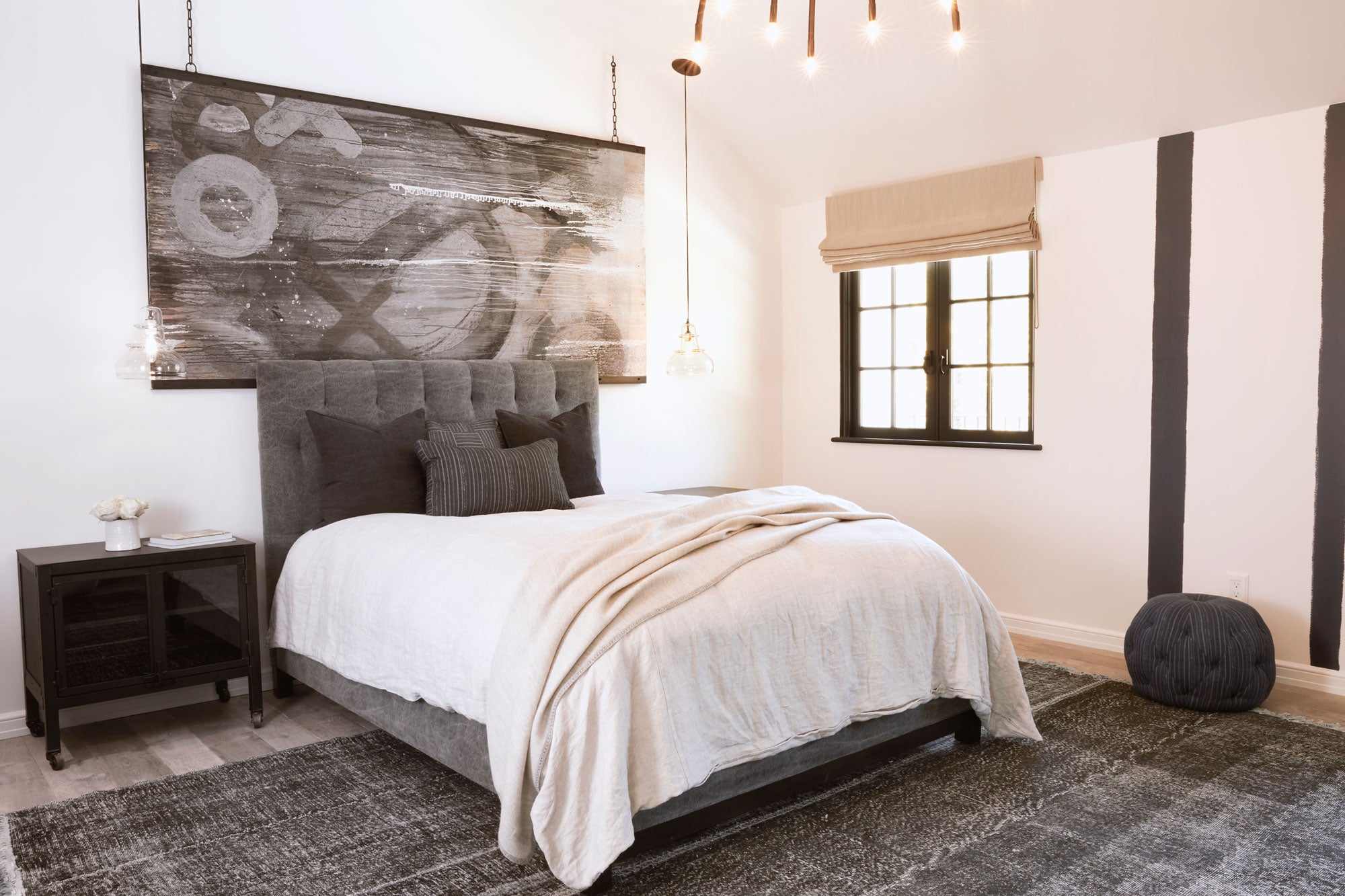 bed in light filled room and pendant glass lighting 