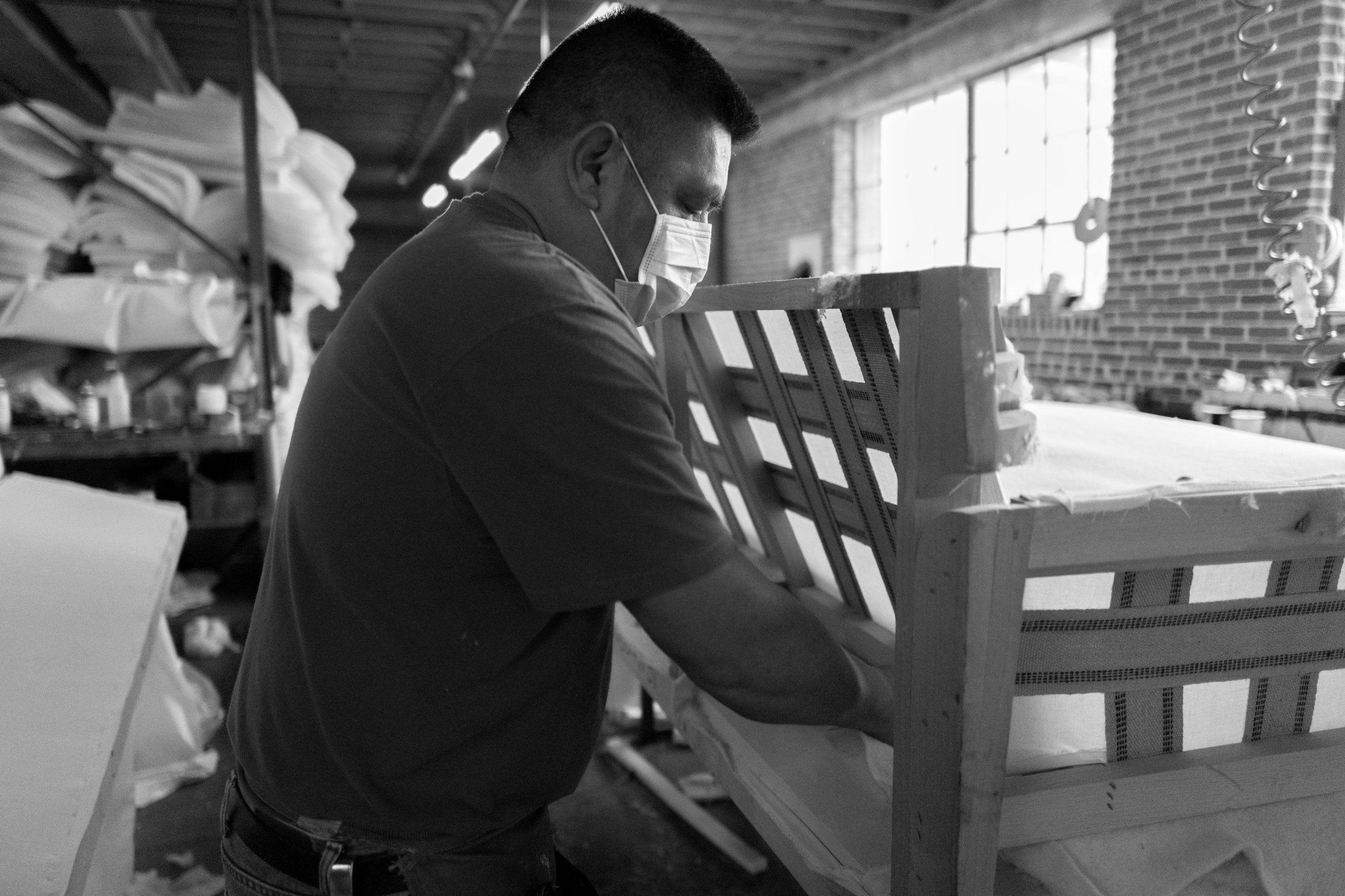 black and white image of a Craftsman working on sofa