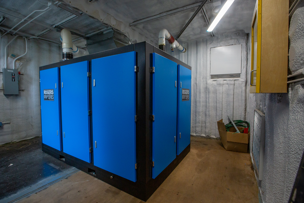 Image of a blue Rogers Machinery KRVP vacuum pump installed in a cabinet manufacturing facility in Washington.
