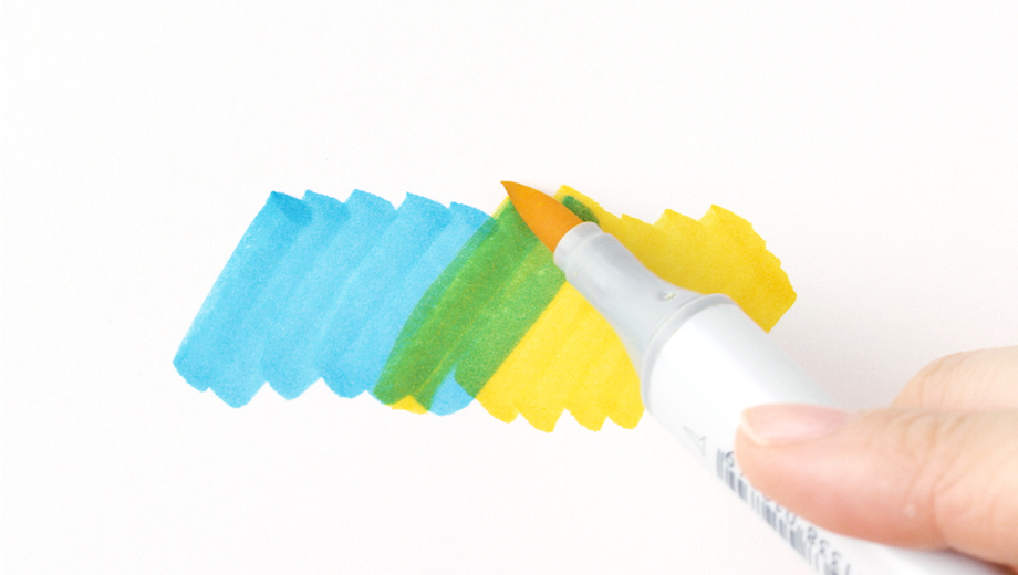 Copic Sketch marker creates new color by layering a blue swatch onto a yellow swatch