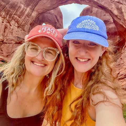 Two women wearing Colorful and Happy Baseball Caps while Hiking in the Mountains