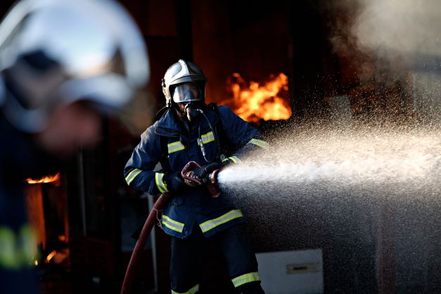 Firefighters try to extinguish a fire that broke out at a transport company