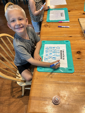 Boy learning to write with Busy Baby Toddler Mat