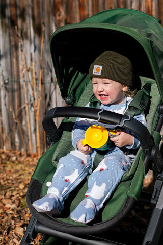 Boy in stroller with busy baby tethers