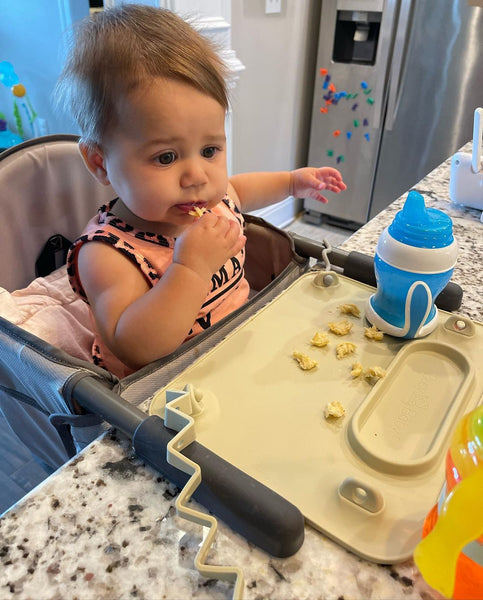 Baby eating snacks with a Busy Baby Mat