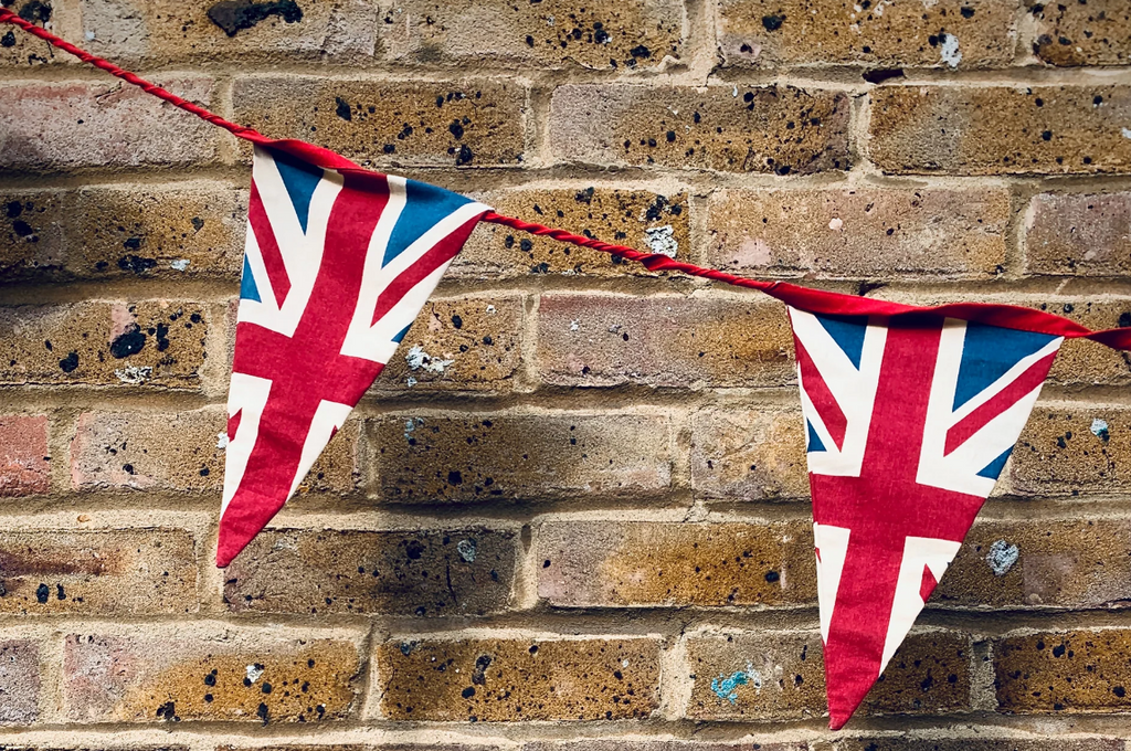 british flag bunting against a brick wall