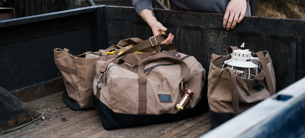 Grabbing the Barebones Neelum Duffel from the back of a pick up truck