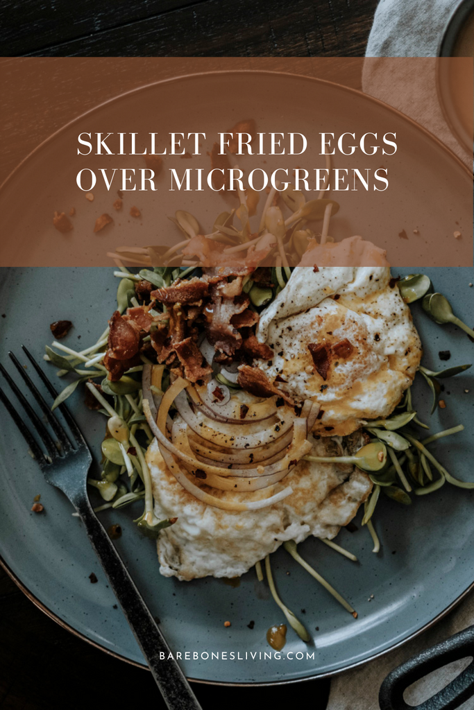 Skillet fried eggs over microgreens with bacon crumbles