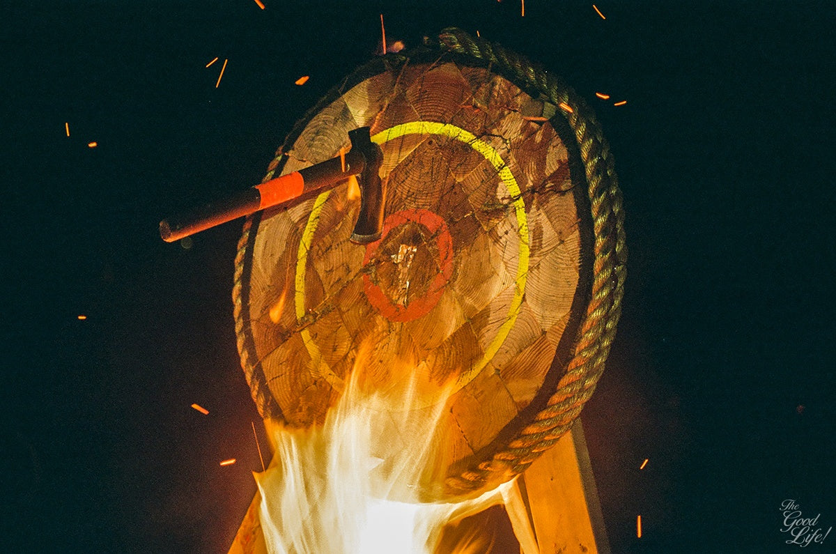 Hatchet in wooden target with fire underneath