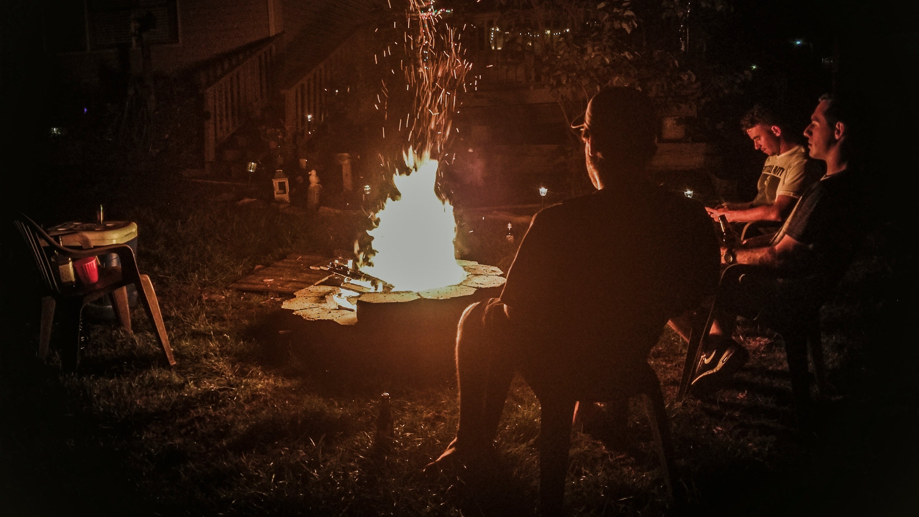 Backyard bonfire with 3 friends sititing around the fire