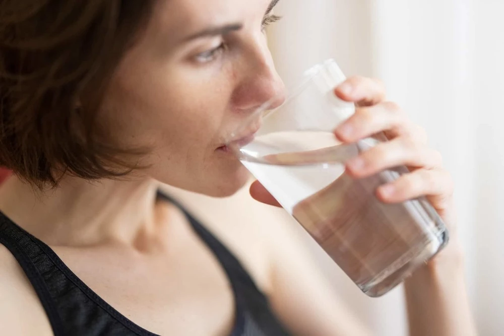 a woman drinking a glass of water