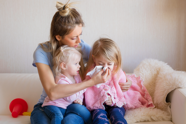 A woman and two children sitting on a couch.