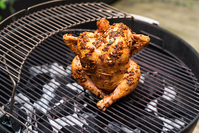 Cooked beer roasted chicken on a Weber Grill.