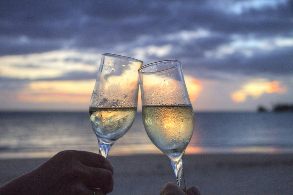 Two people holding up a toast at the beach