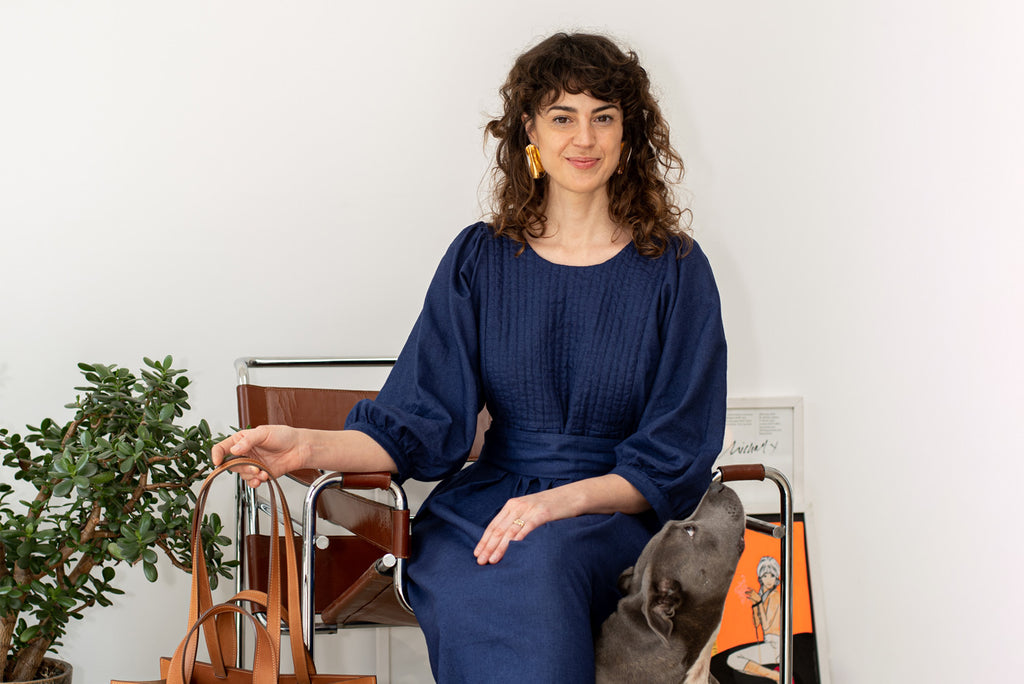 Ana Abalon Studios wears THE REGULAR Quilt Dress in workwear blue and tan leather 'Pioneer' Tote bag