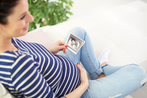 pregnant mother in striped shirt looking at ultrasound