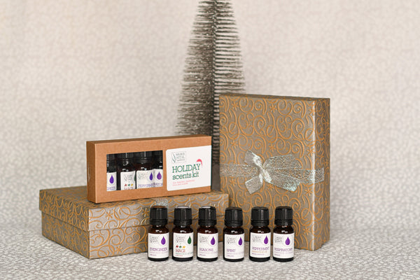 Source Vital Holiday Scents Kit surrounded by gift packages and a silver tree