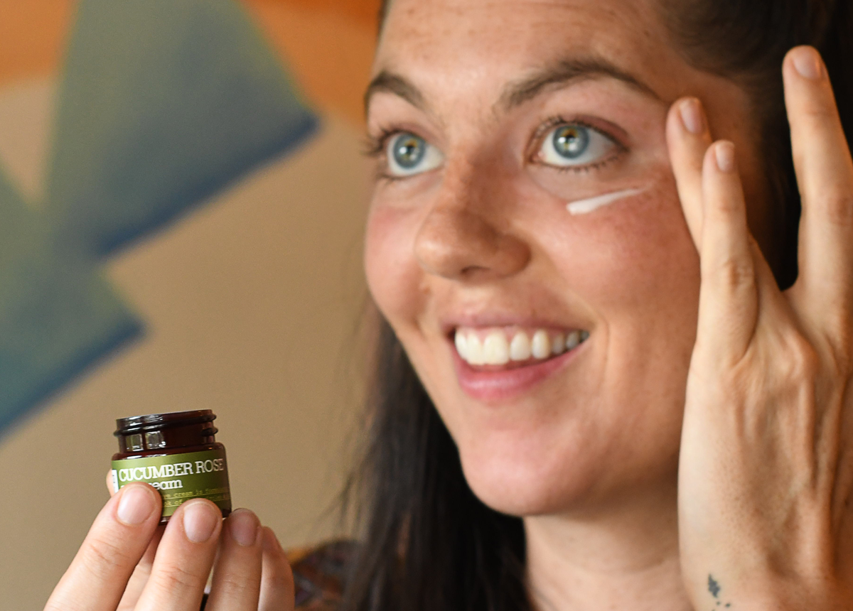 woman applying source vital apothecary cucumber rose eye cream under her eyes