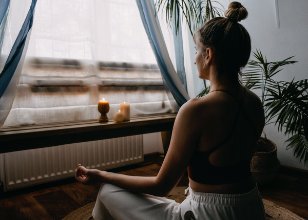 Woman looking out window while meditating