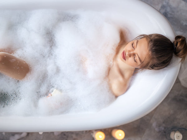 Woman relaxing in bubble bath from above