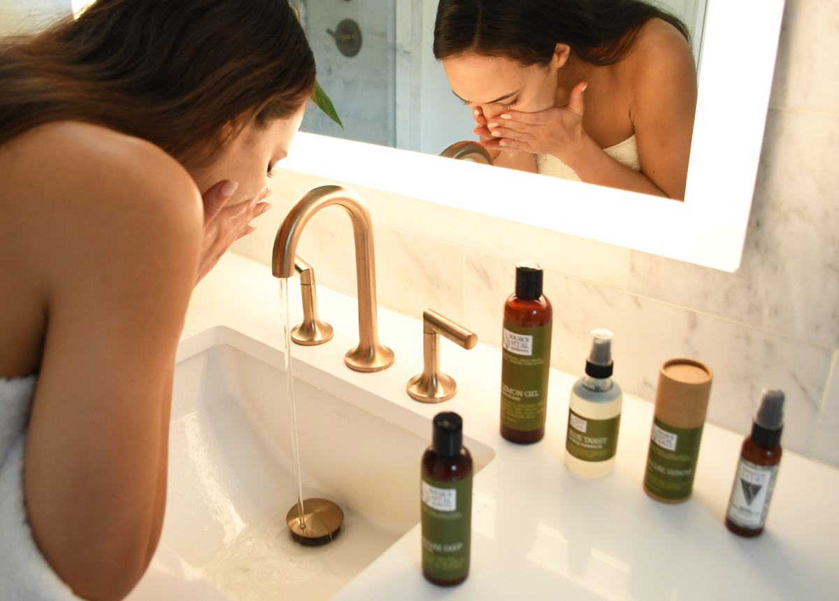 woman washing face as part of natural skin care routine