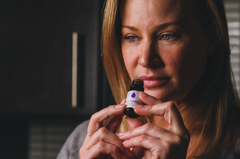 women smelling essential oils out of the bottle