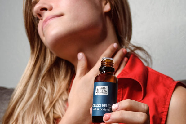 Woman applying Stress Relief Bath & Body Oil to neck