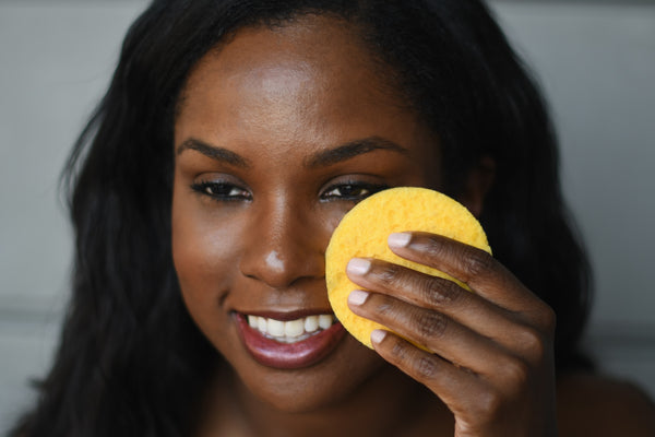 Woman cleansing her skin with a sponge
